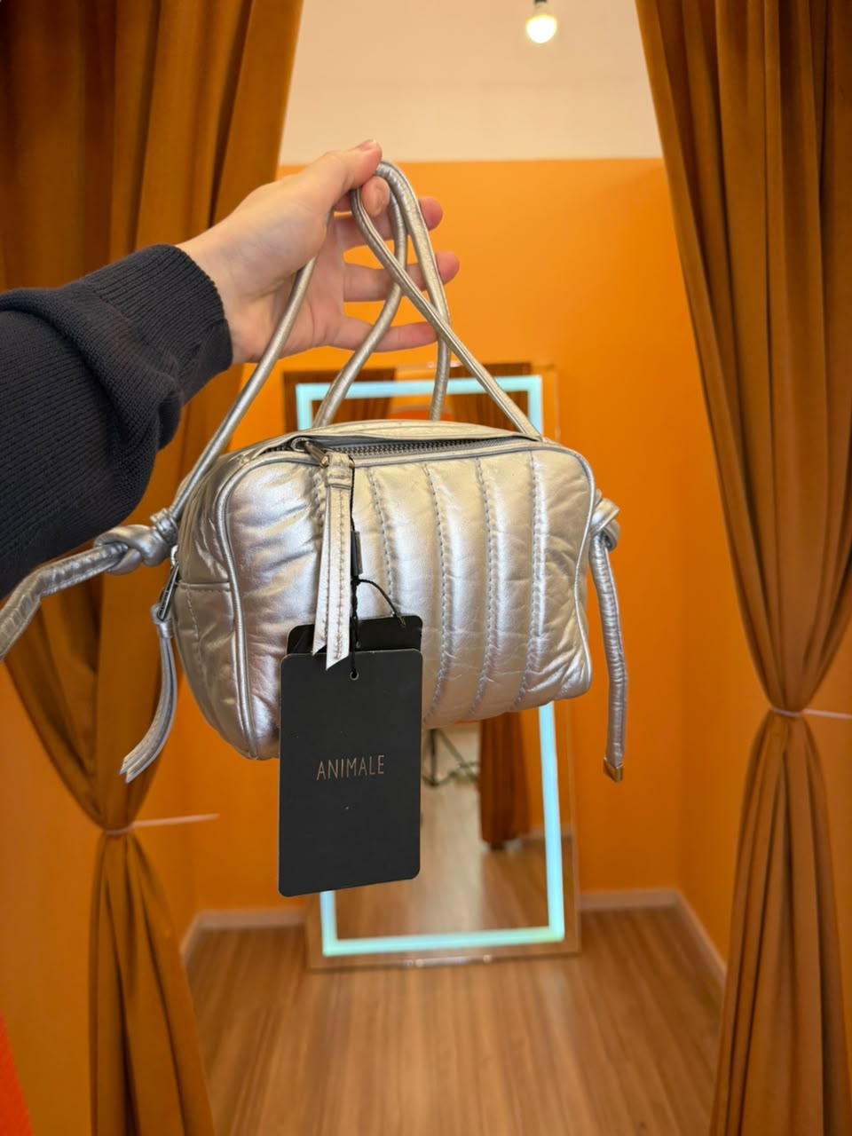 Bolsa prateada Animale no provador laranja